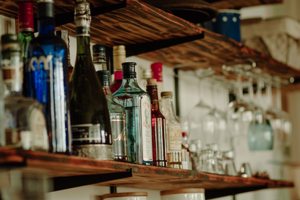 collection of alcoholic beverage bottles on a bar shelf showing various alcohol types and their effects on inflammation