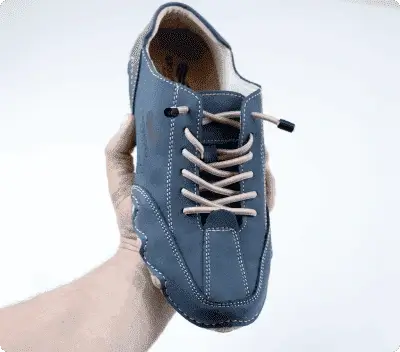 hand holding Grounded Evolve barefoot shoe in blue showing ergonomic design and flexible zero-drop sole for natural alignment and foot movement