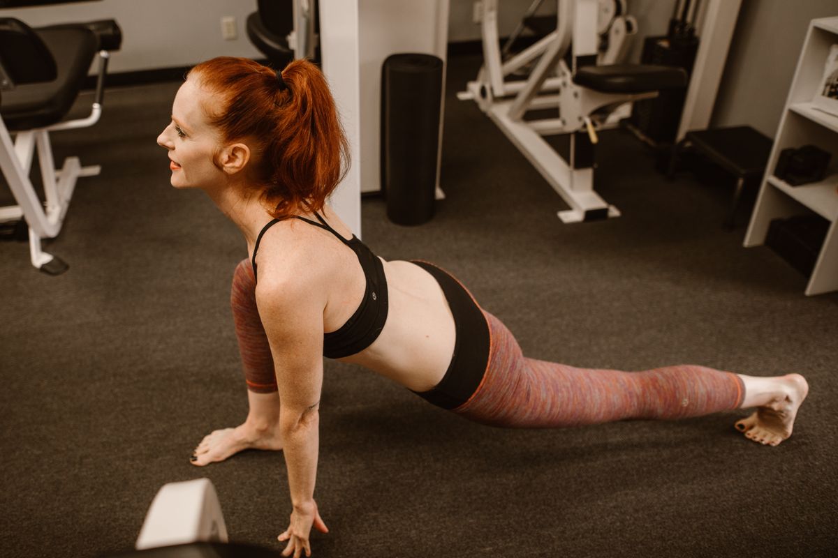 woman stretching hip muscles in gym