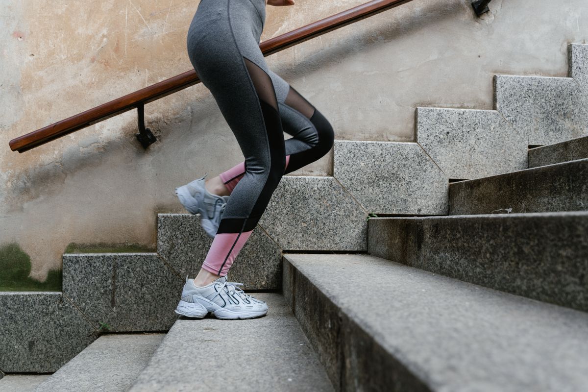 woman climbing concrete stairs with knee discomfort