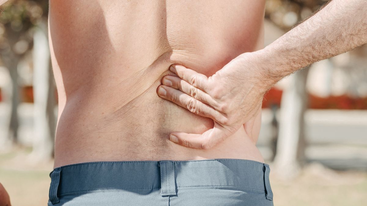 man holding lower back in pain