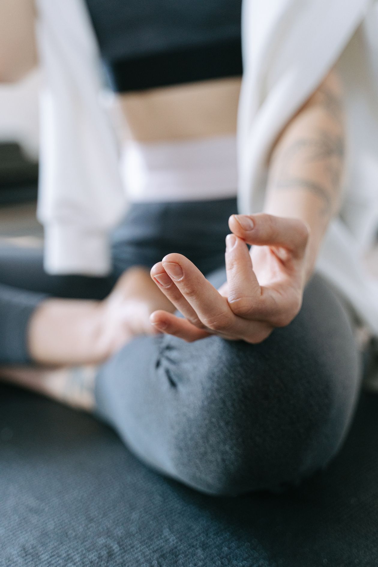 person in meditative hand position during yoga session promoting calm and stress relief