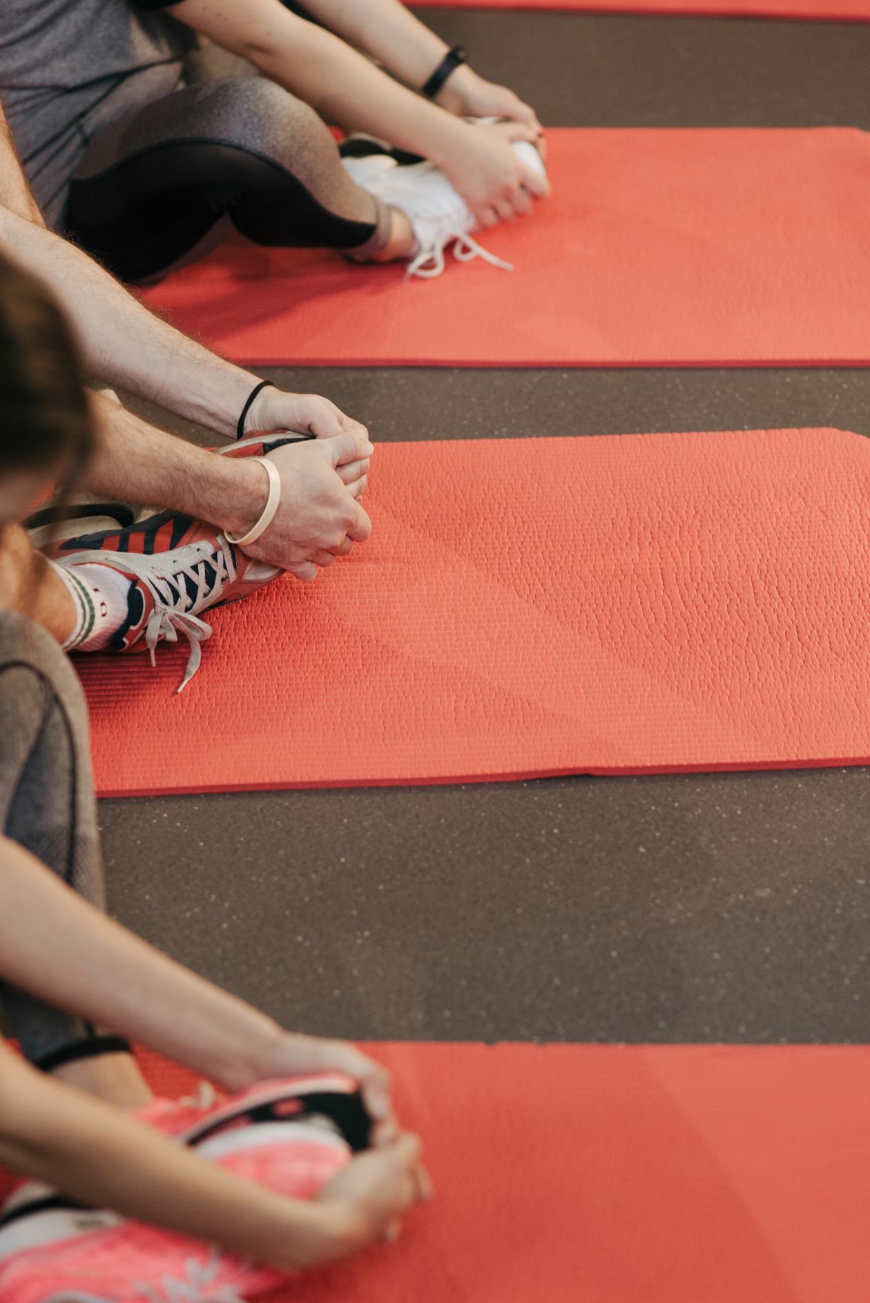 participants stretching on yoga mats in a flexibility class representing Pilates exercises for back pain