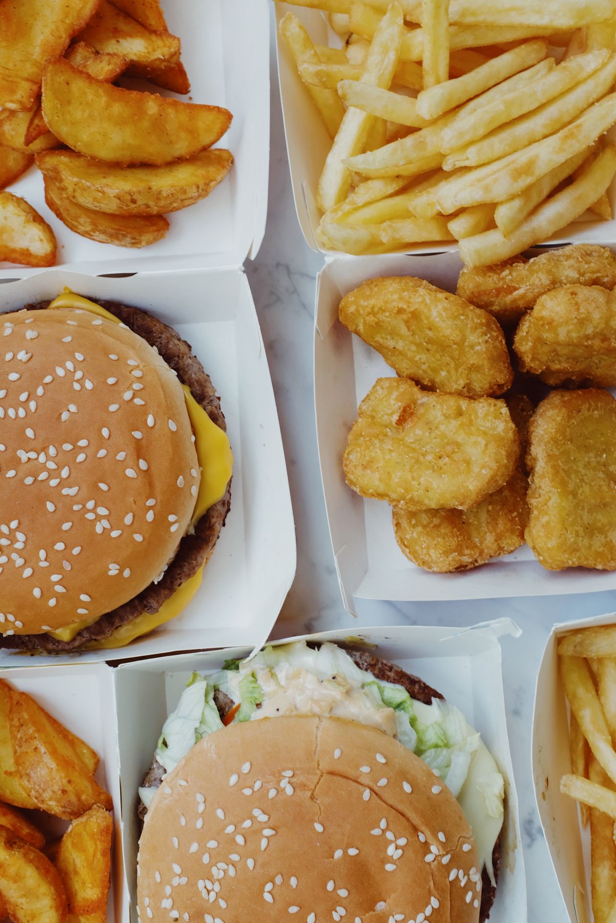 close-up of junk food including burgers nuggets and fries showing ultra-processed inflammatory foods