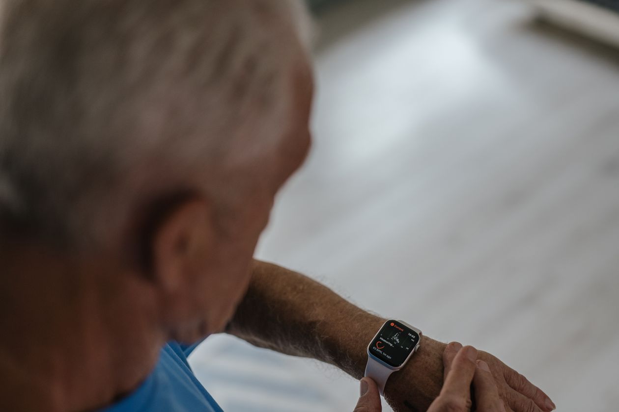 senior man checking his smartwatch indoors for fitness tracking