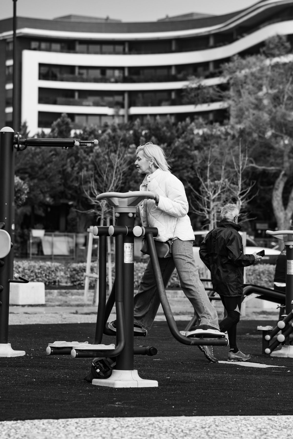 senior adults exercising on outdoor gym equipment in city park