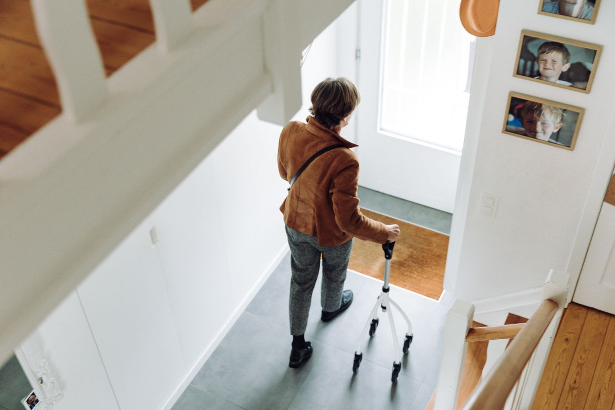 senior using rollator walker indoors for mobility support and fall prevention at home showing independence and safety