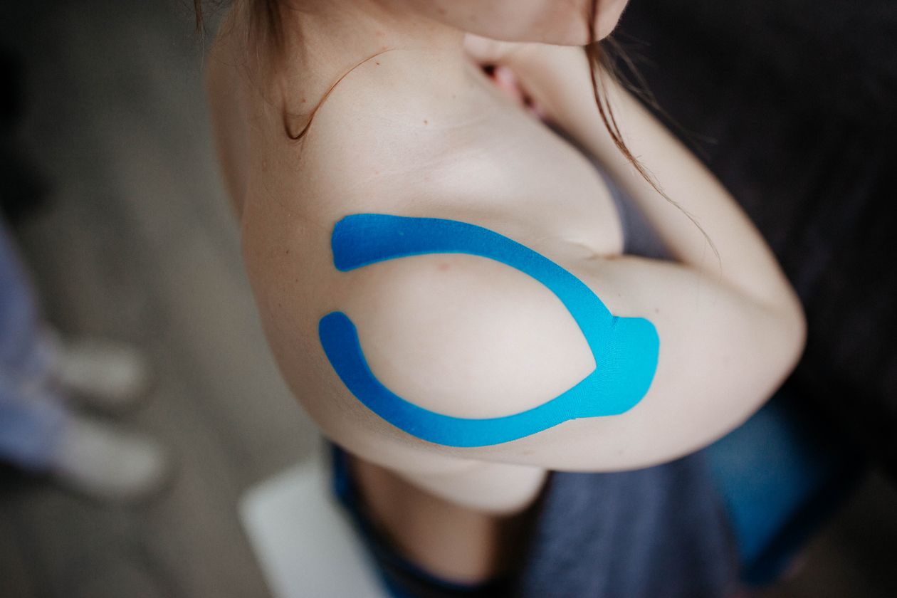 kinesiology tape applied to shoulder for muscle support and pain management