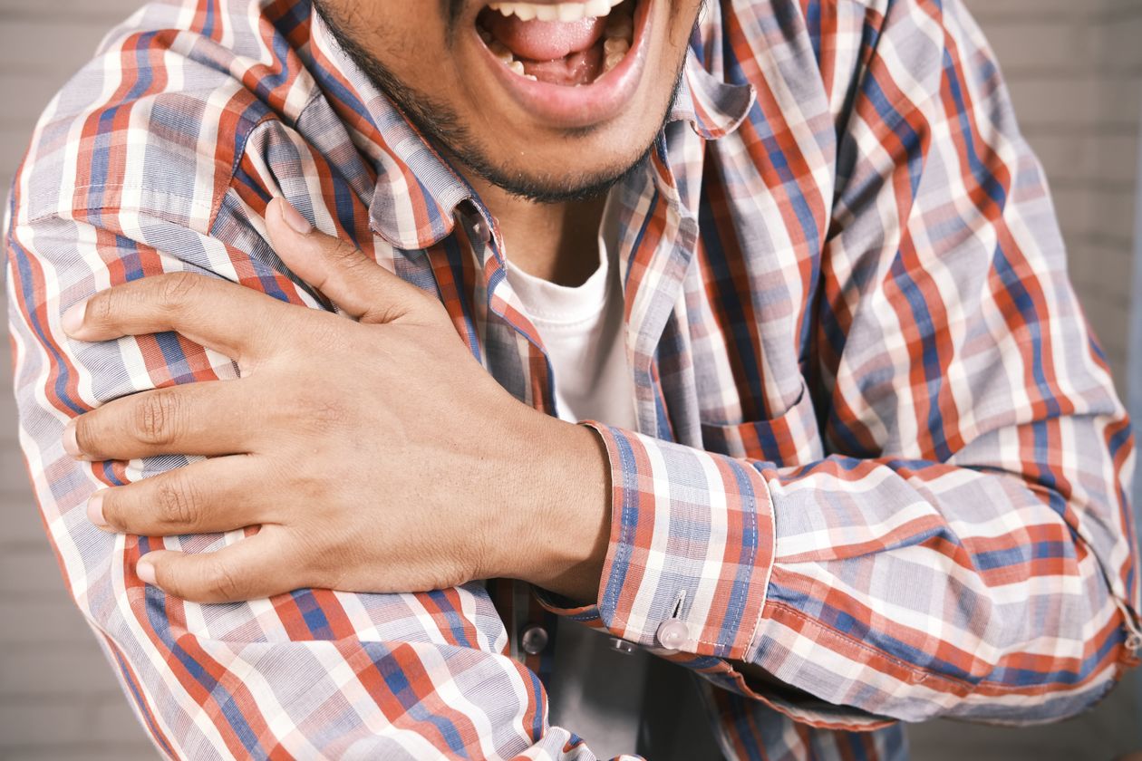man holding his shoulder in pain showing shoulder pain common in adults over 40