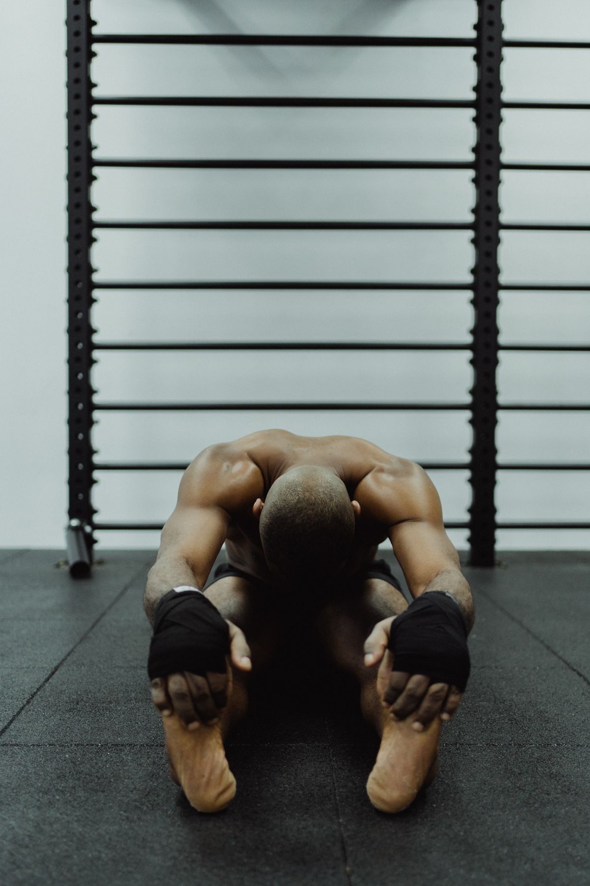 male athlete performing seated forward stretch for muscle recovery