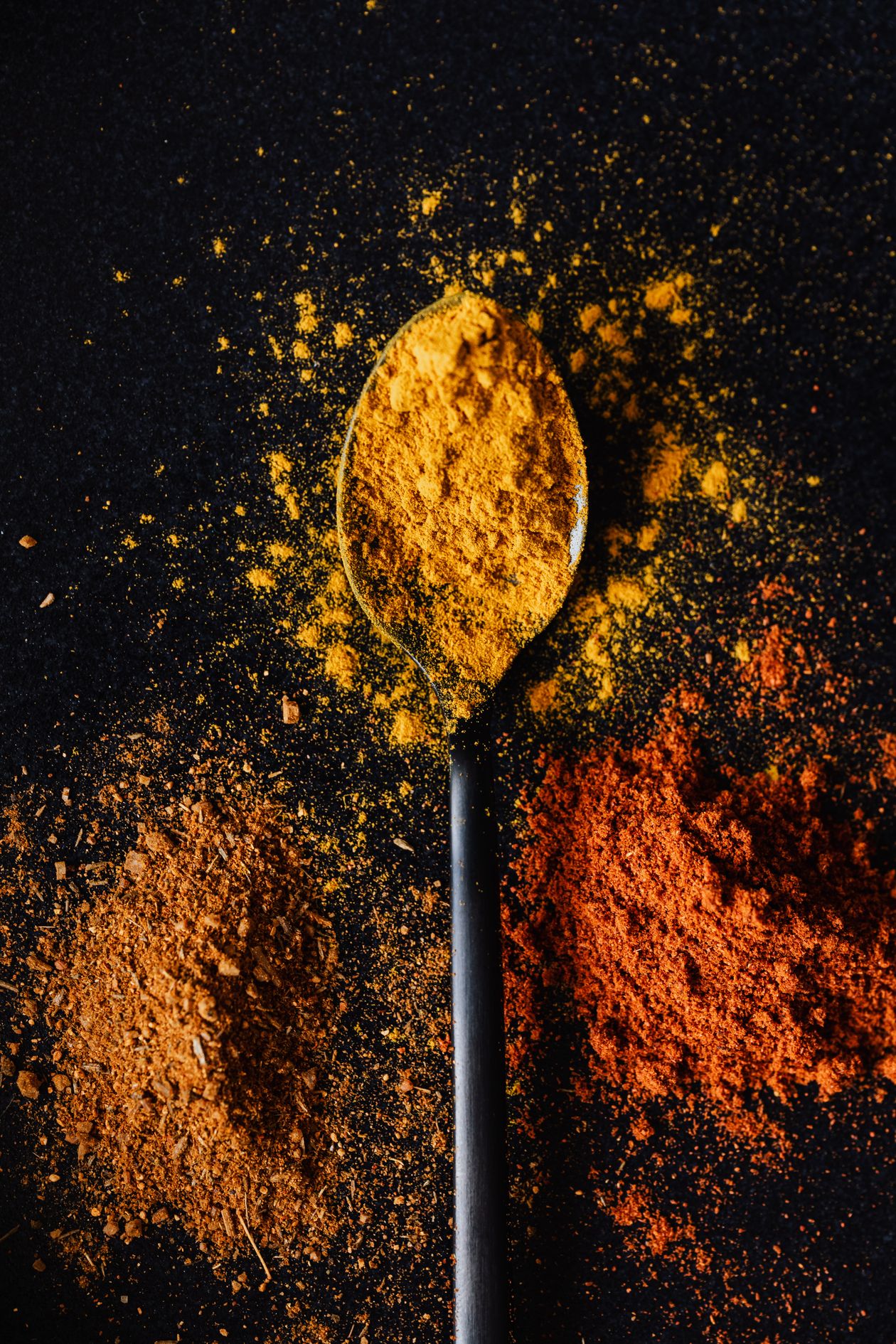 turmeric powder in spoons alongside other anti-inflammatory spices for joint health