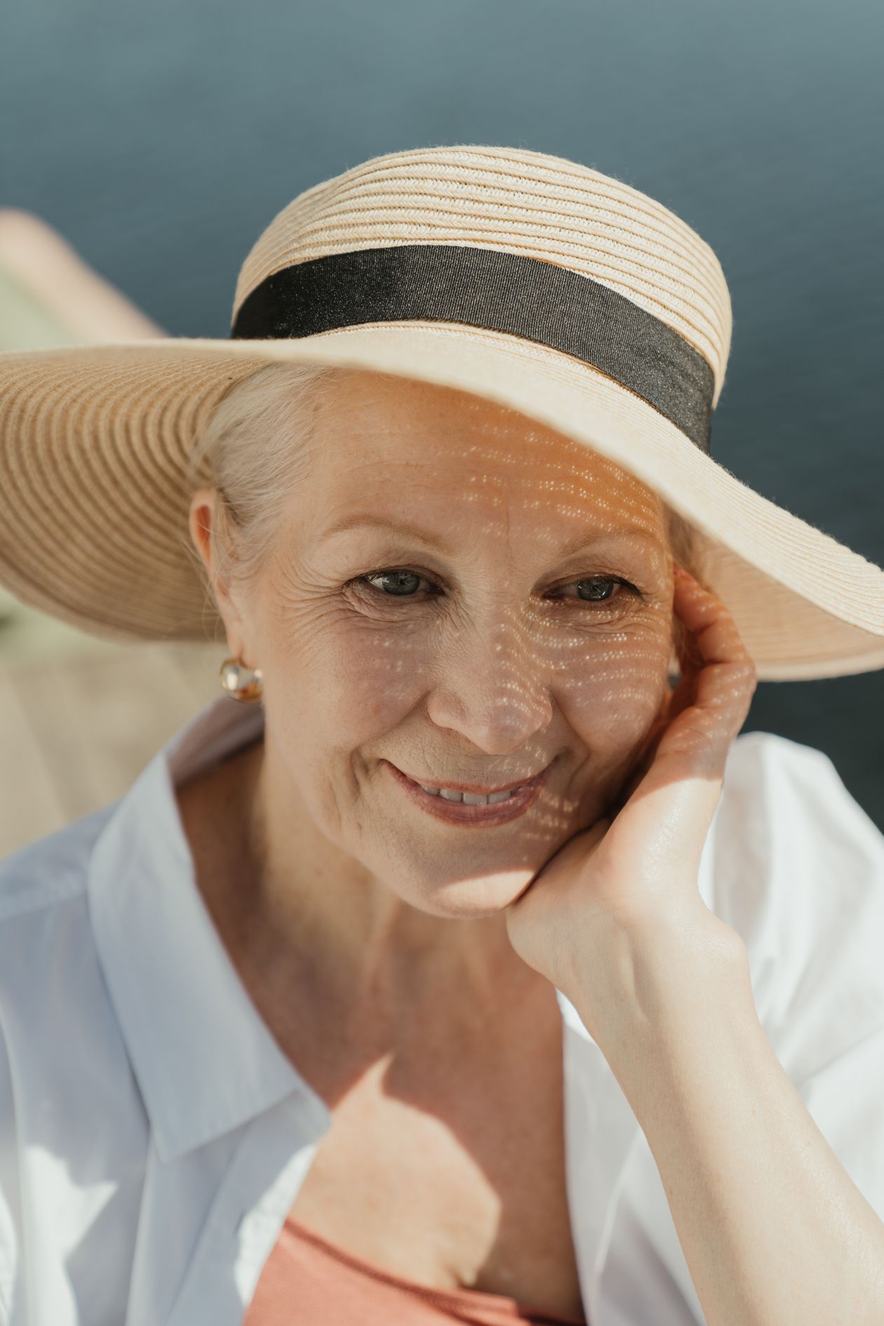 elderly woman smiling in sunlight outdoors showing importance of sun exposure for vitamin D after 40