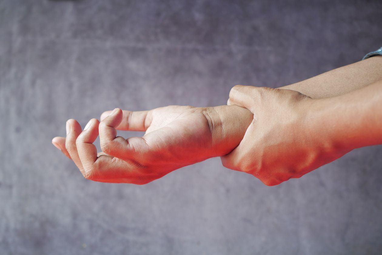 close-up of hands with one grasping the other symbolizing wrist or hand joint pain in adults