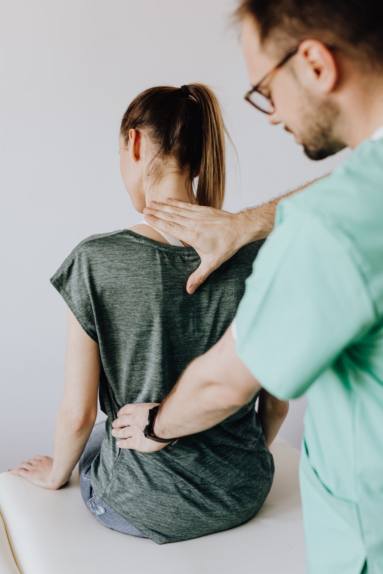Medical professional examining patient back posture
