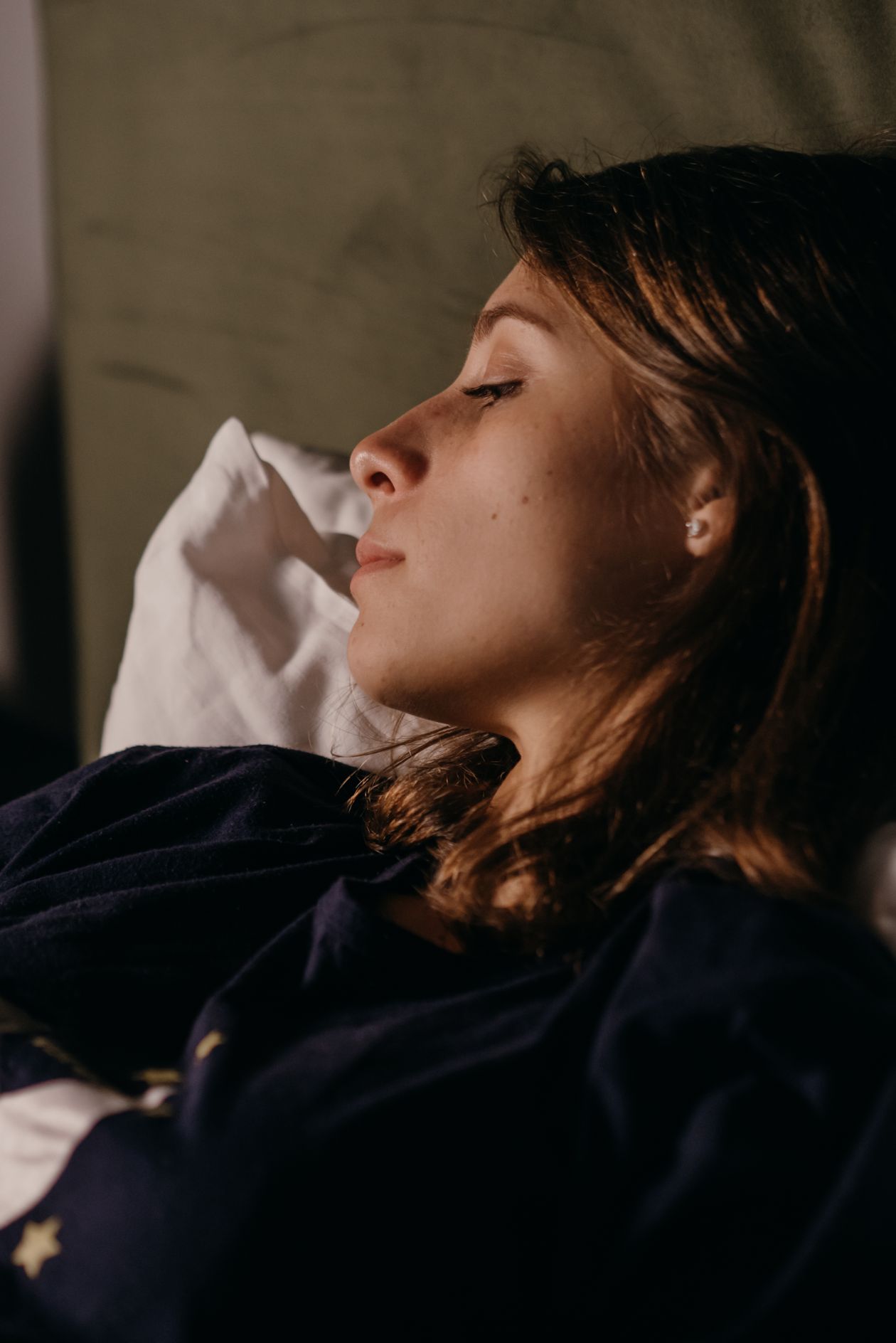 Person sleeping comfortably in bed representing best sleep positions for pain relief