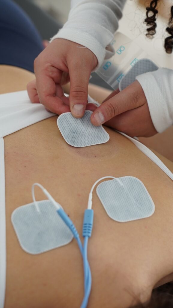 Physiotherapy session with EMS electrotherapy electrode pads on leg