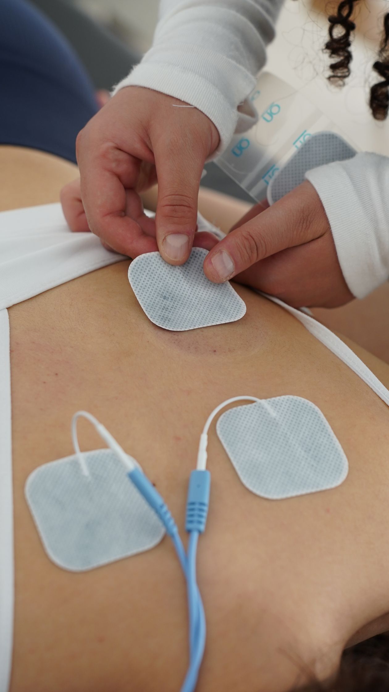 Physiotherapy session with EMS electrotherapy electrode pads on leg