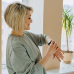 Adult over 40 smiling while checking health and activity data on a fitness watch