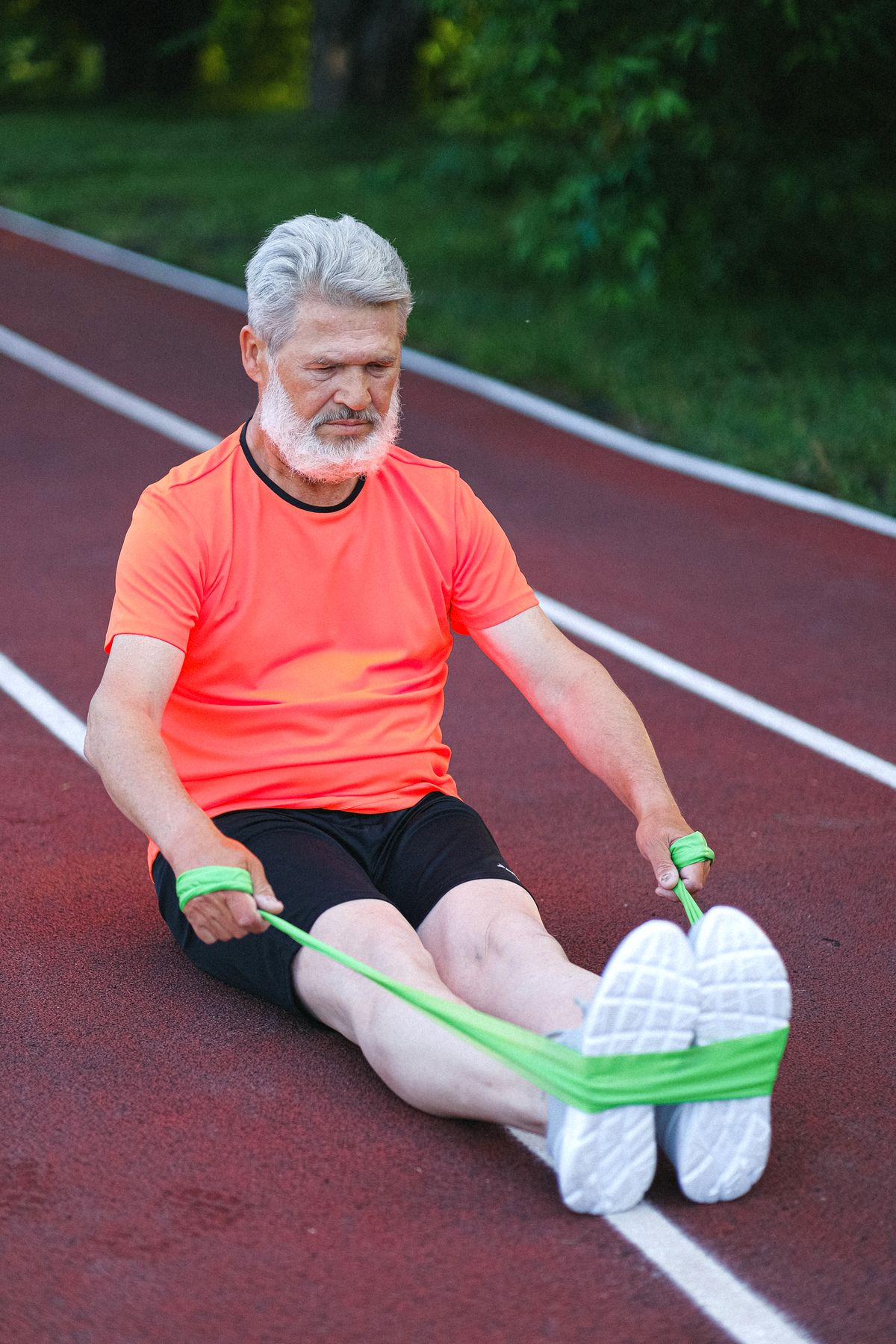 Older man stretching with a resistance band during a recovery day, supporting muscle repair after 40