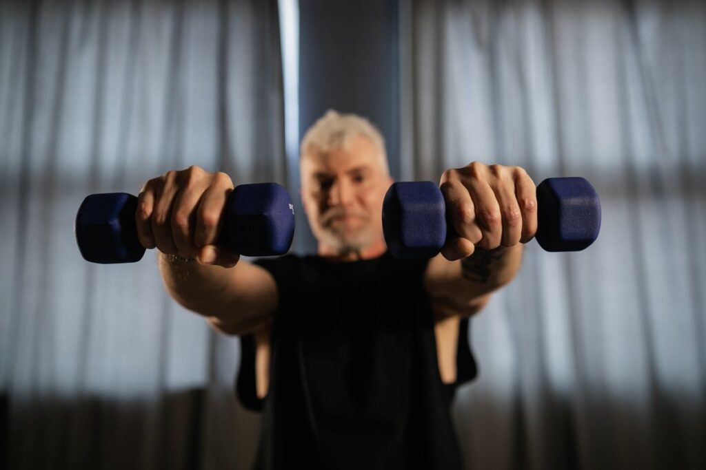 Older man doing strength training with dumbbells to prevent sarcopenia and muscle loss after 40