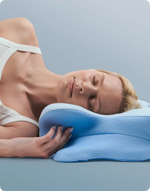 Side sleeper resting on the raised wing of the Hewelth MaxBreath butterfly pillow with the shoulder tucked into the curved edge