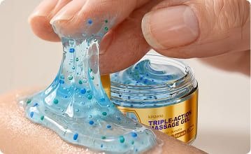 Close-up of Kinzeno massage gel texture being lifted from the jar, showing the blue gel and coloured microbeads