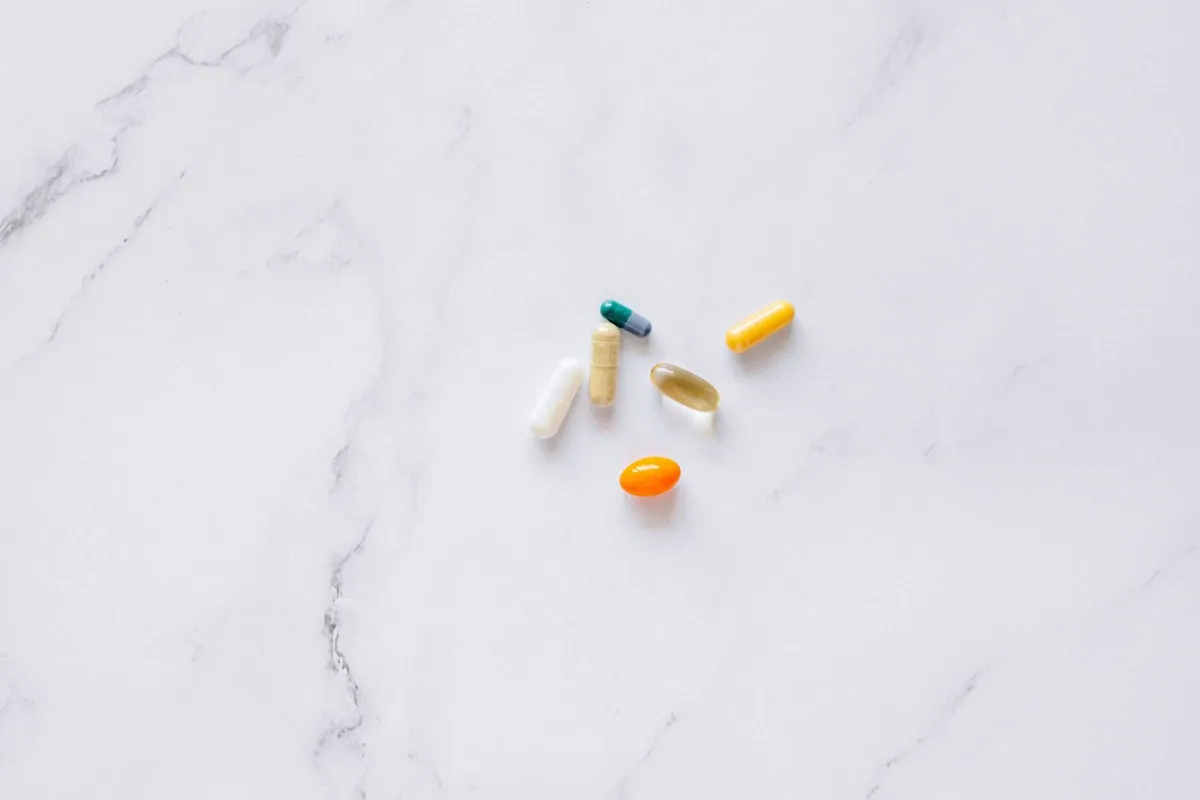 Daily joint supplement capsule held in hand, part of an evidence-based routine for joint pain after 40