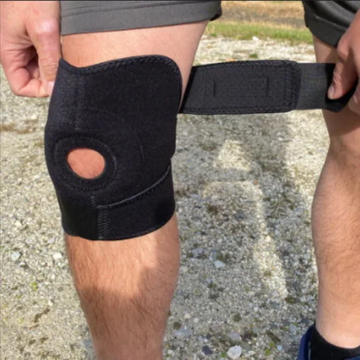 Dr. Flexa knee brace with the wide velcro strap open, showing the open-patella cutout and neoprene body