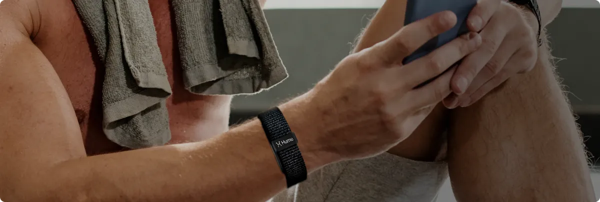 Man wearing the Hume Band 2.0 after a workout while checking his phone