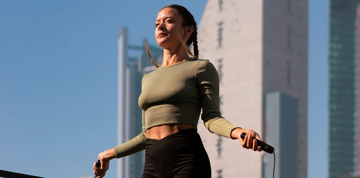 Woman wearing the Hume Band 2.0 while jumping rope outdoors